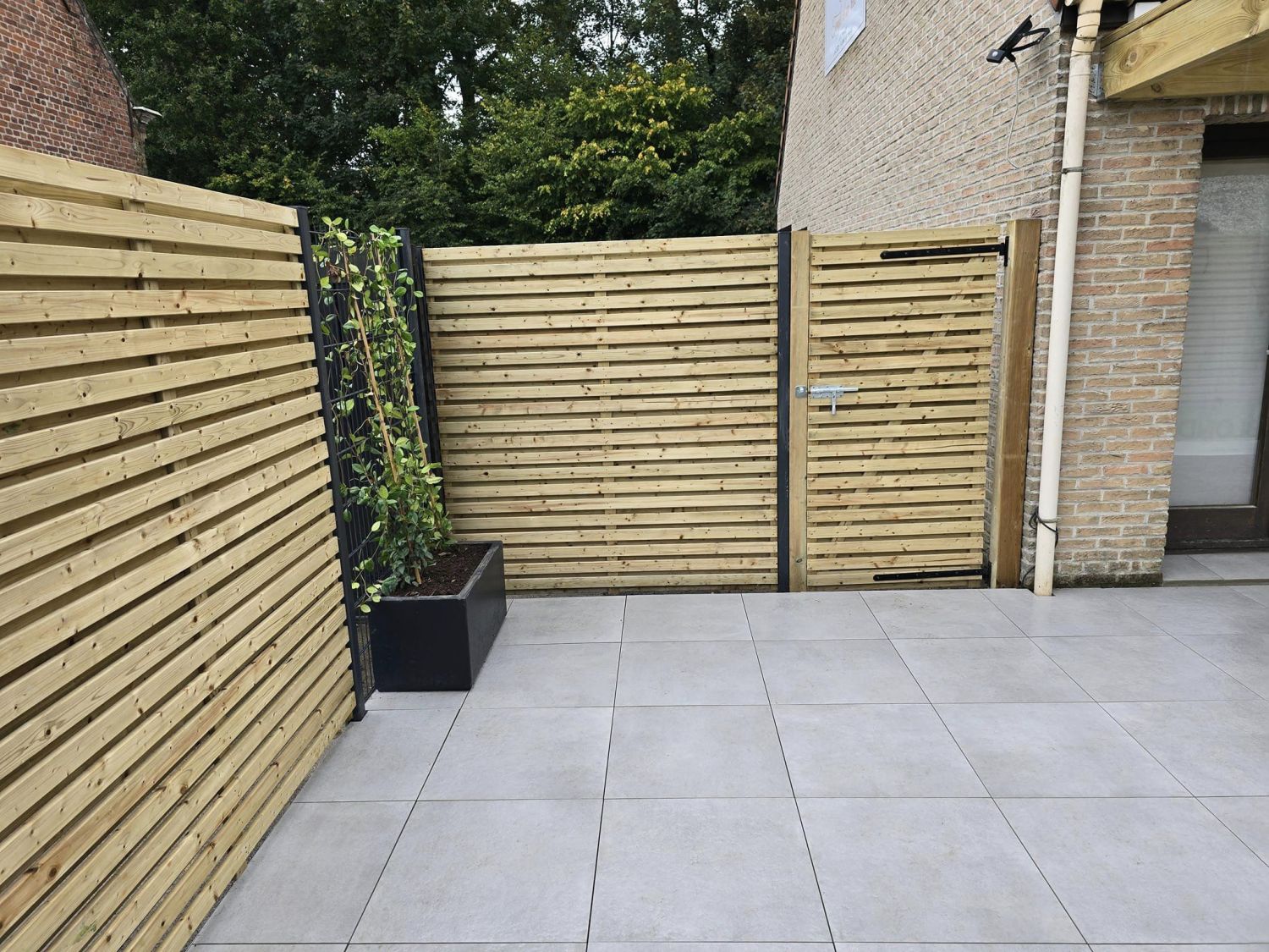 Terrasse, clôture, portillon, gazon synthétique, pergolas, jardinières 